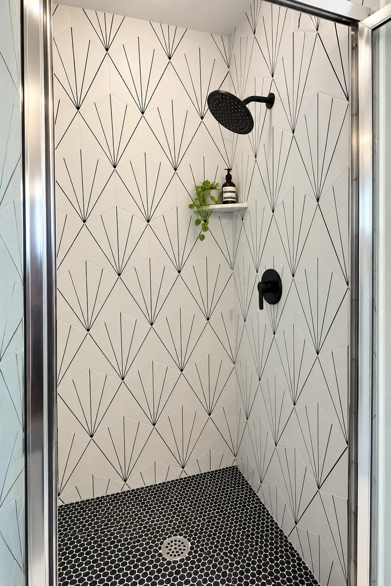 Art-deco patterned tile shower with black hexagon mosaic floor in a Clovis, CA bathroom remodel