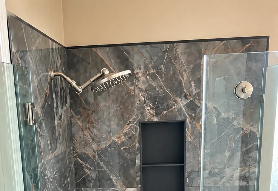 Frameless glass shower enclosure with marble-look tile completed in a Clovis, CA bathroom remodel